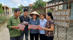 hình ảnh về 3 người dân việt nam đang cầm sổ hồng và đứng ở hàng rào bàn tán với nhau về những thắc mắc Đất Nhận Thừa Kế Nhưng Chưa Sang Tên Có Bán Được Không?